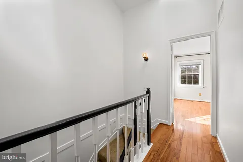a view of a hallway with wooden floor and staircase
