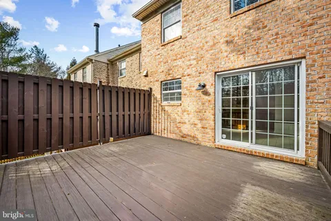 a view of backyard with large trees and wooden fence