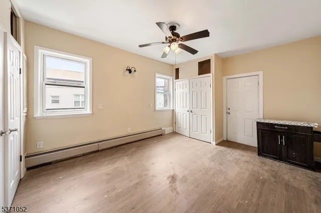 an empty room with windows and fan