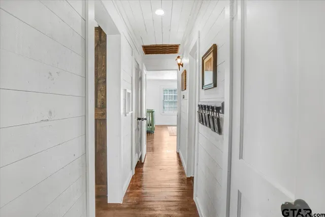 a view of a hallway with wooden floor and staircase