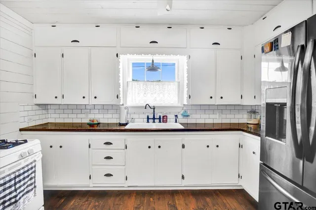 a kitchen with granite countertop white cabinets white stainless steel appliances with a sink and dishwasher