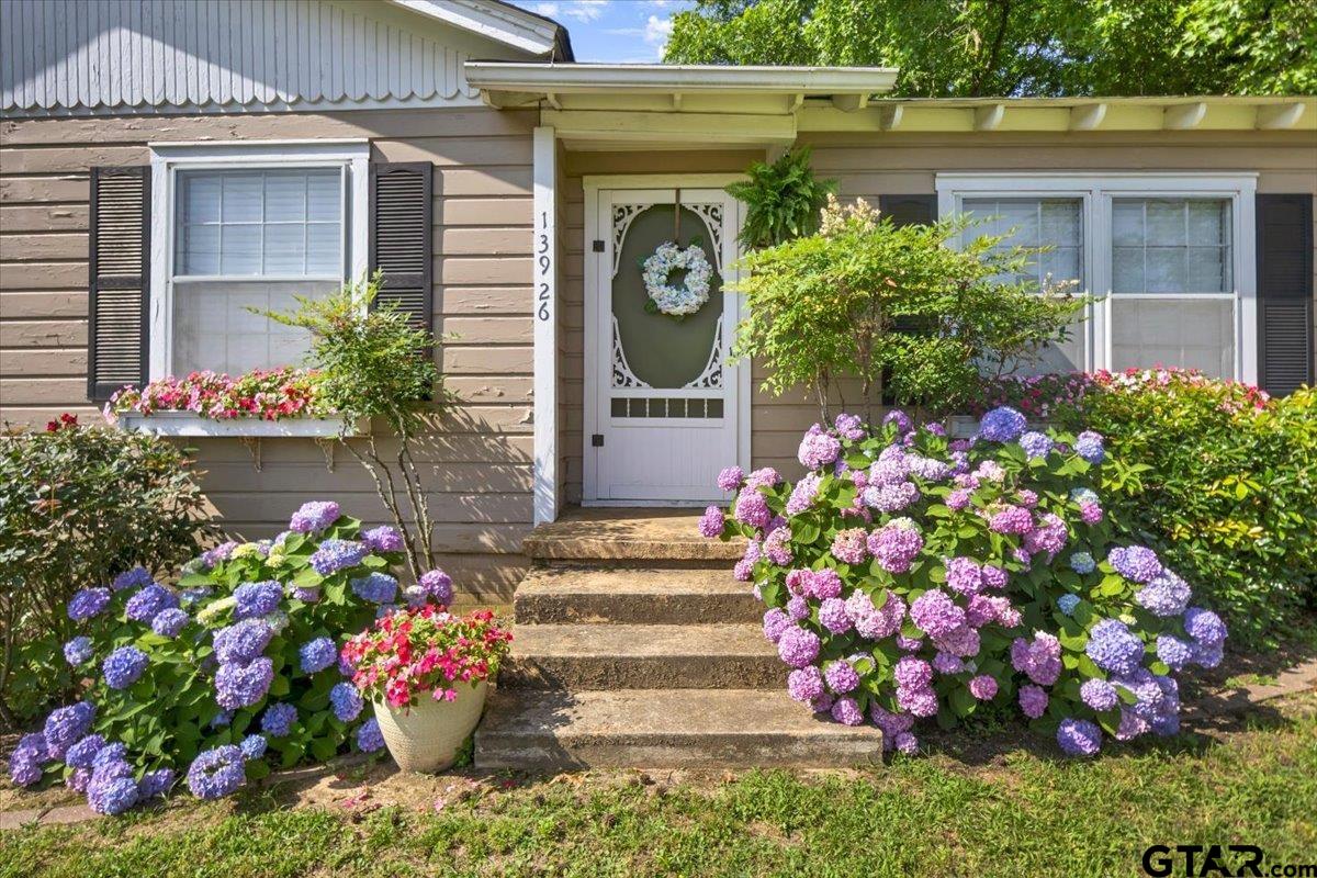 13926 State Highway 64 Tyler, TX 75707 - Photo 27 of 34 a front view of a house with a yard and flowers in it