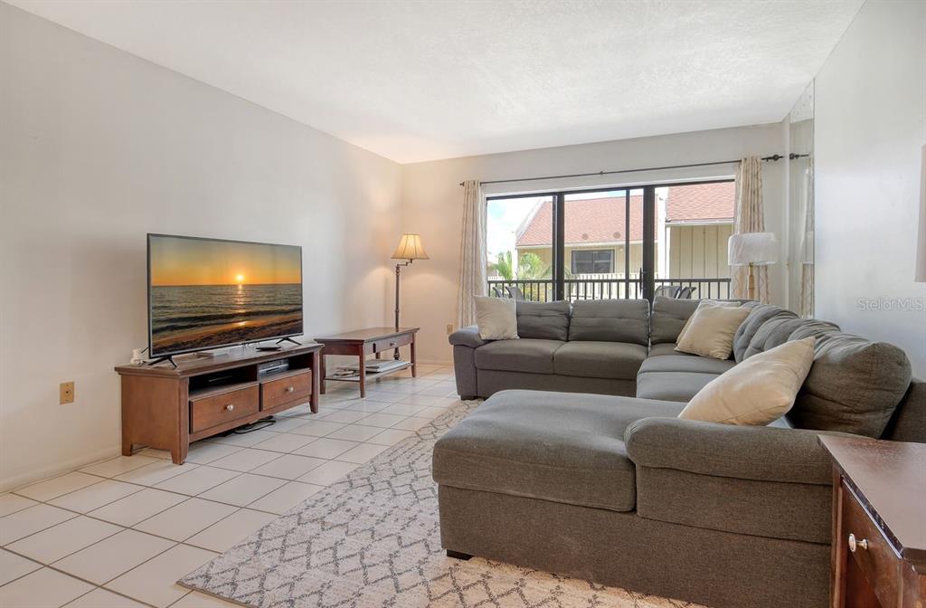 6157 Midnight Pass Road, Unit E63 Sarasota, FL 34242 - Photo 9 of 61 a living room with furniture and a flat screen tv