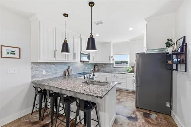 a kitchen with white cabinets stainless steel appliances and a sink