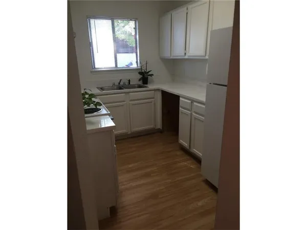 a kitchen with a sink cabinets appliances and a window