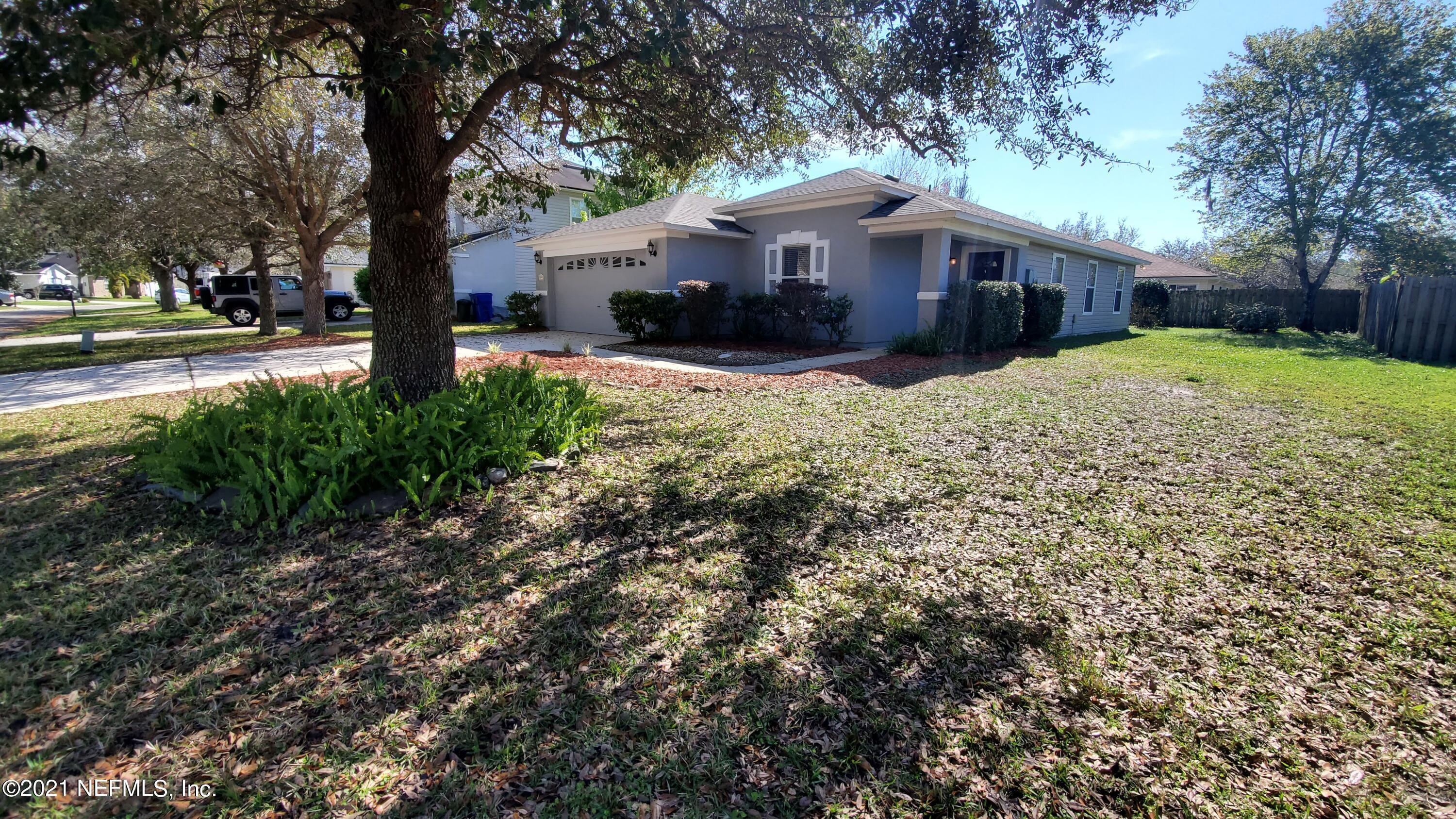 658 MacKenzie Circle St. Augustine, FL 32092 - Photo 3 of 13 a front view of a house with a yard and large tree