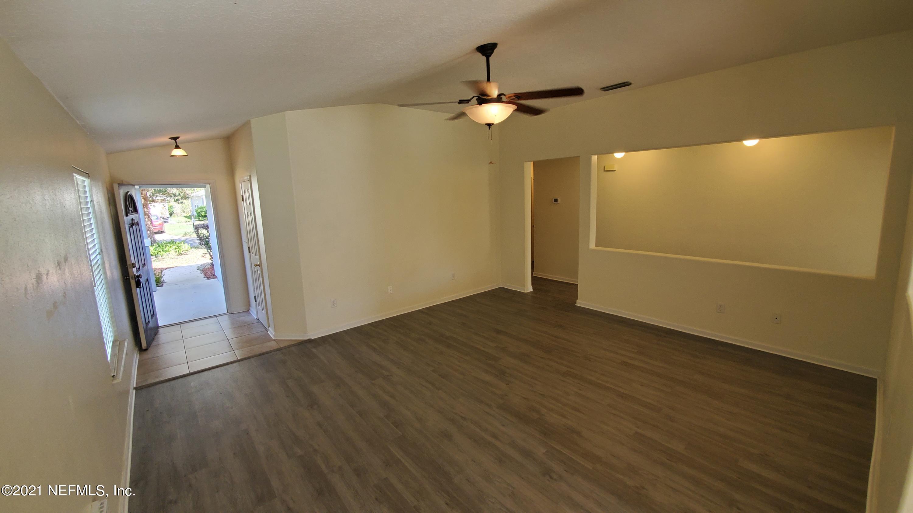 658 MacKenzie Circle St. Augustine, FL 32092 - Photo 5 of 13 an empty room with wooden floor a ceiling fan and windows