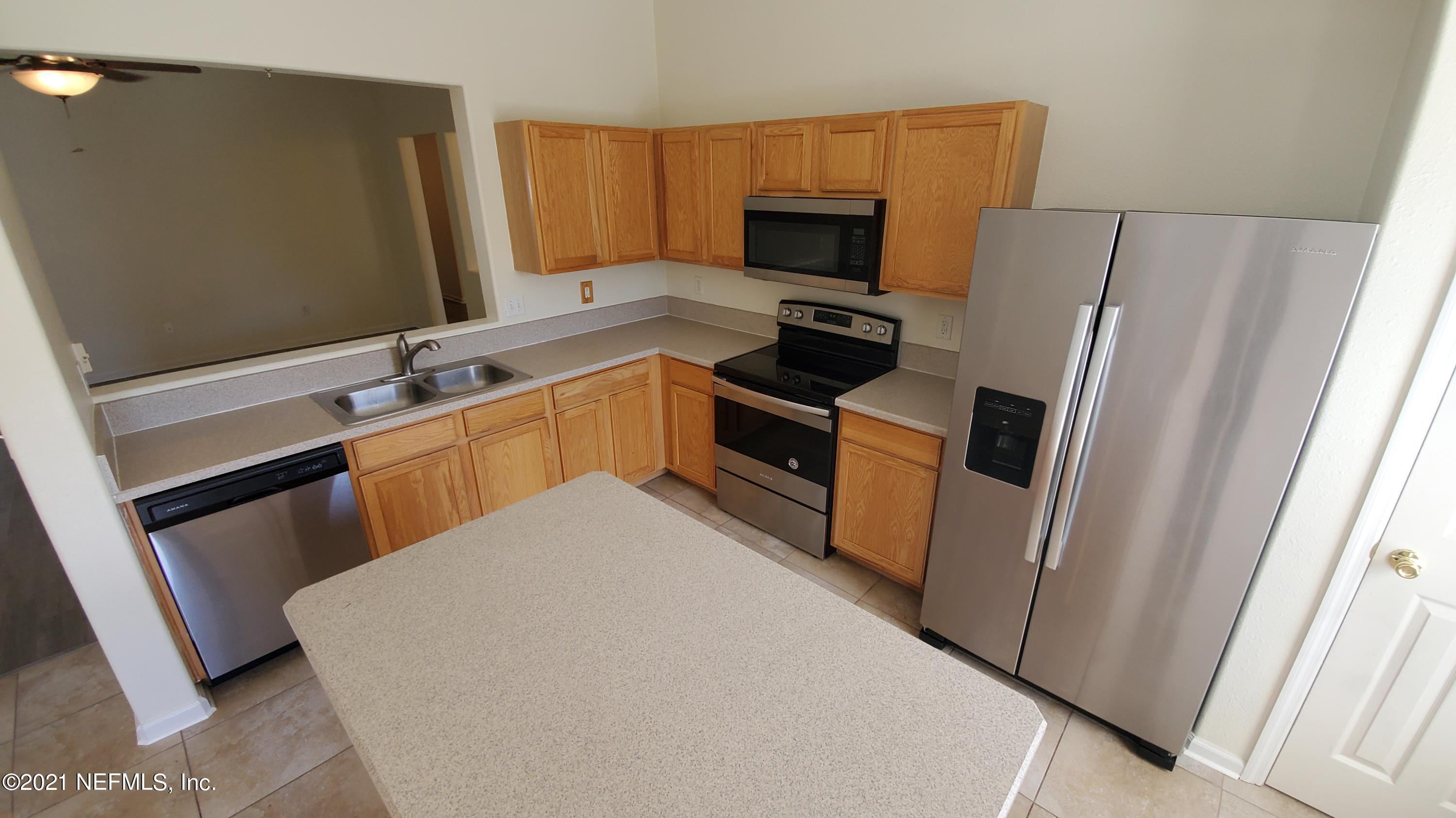 658 MacKenzie Circle St. Augustine, FL 32092 - Photo 7 of 13 a kitchen with a sink a refrigerator a stove top oven and a window
