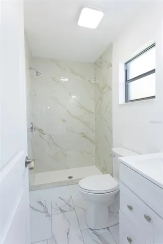 a bathroom with a toilet a sink and shower