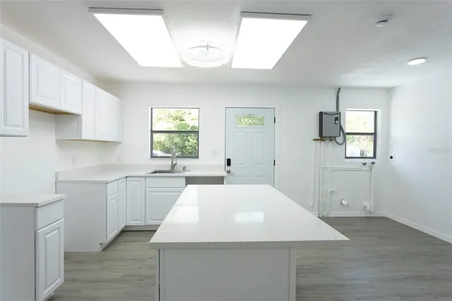 a kitchen with a white cabinets and window