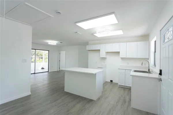 a kitchen with cabinets wooden floor and a sink