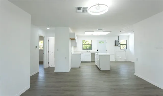 a view of a kitchen with furniture and wooden floor