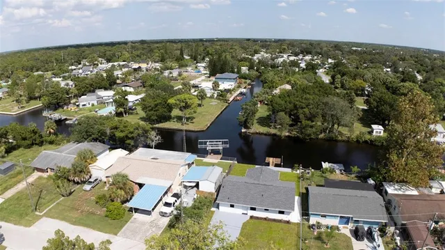 an aerial view of residential houses with outdoor space and trees