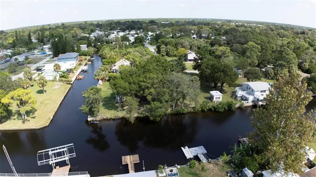 an aerial view of residential houses with outdoor space and lake view