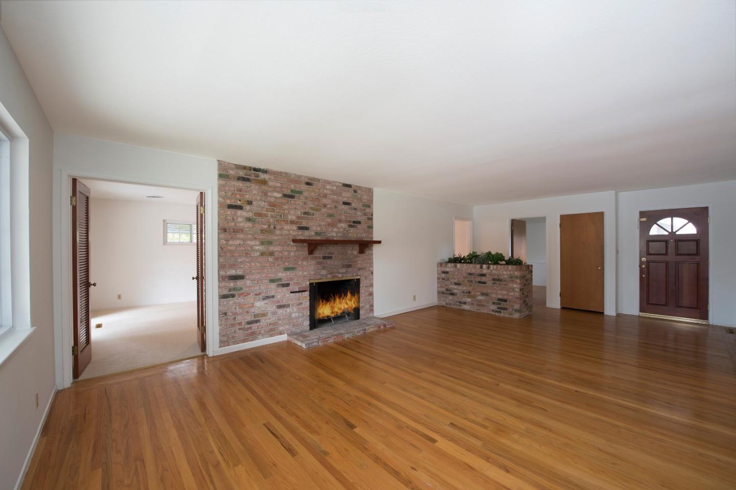 952 Covington Road Los Altos, CA 94024 - Photo 3 of 18 a view of empty room with wooden floor and fireplace