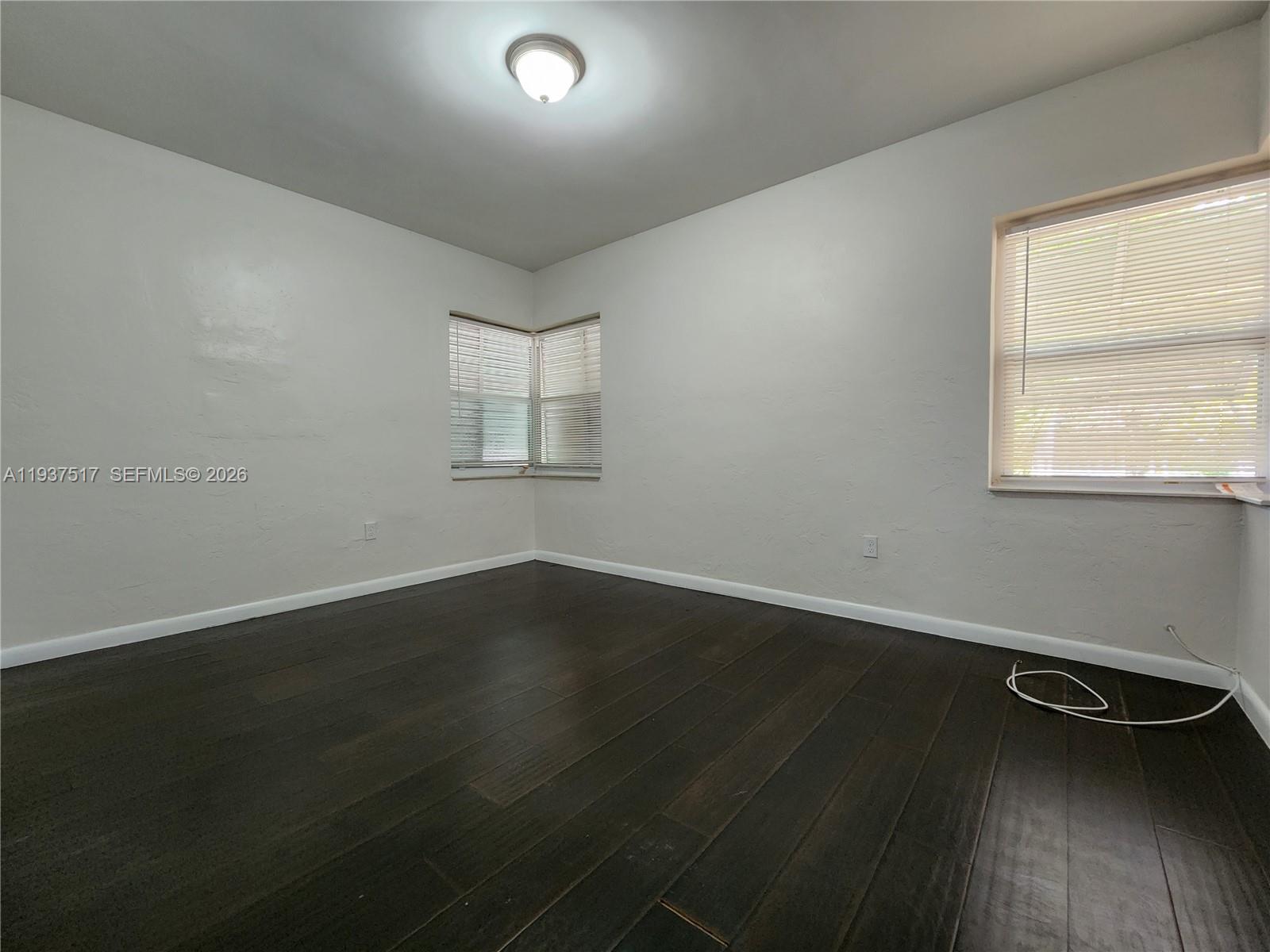 8335 Northeast 3rd Avenue, Unit 1 Miami, FL 33138 - Photo 8 of 12 an empty room with wooden floor and windows