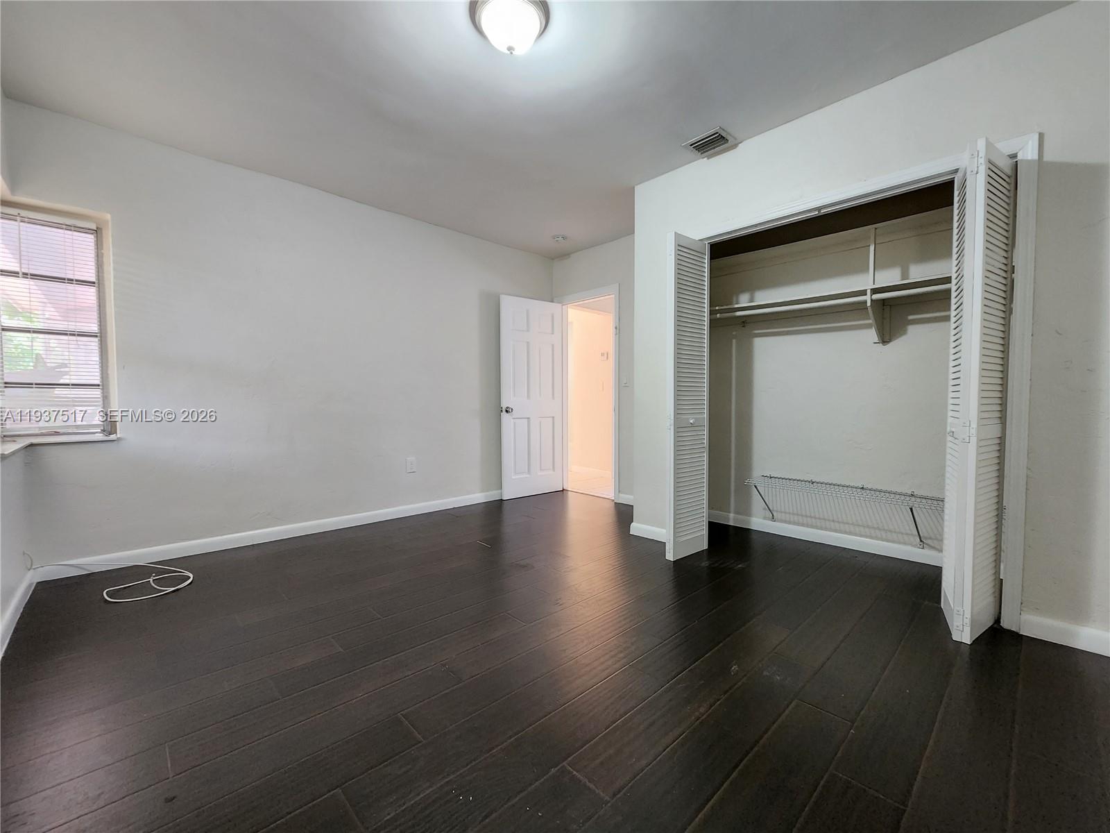 8335 Northeast 3rd Avenue, Unit 1 Miami, FL 33138 - Photo 9 of 12 an empty room with wooden floor & closet area