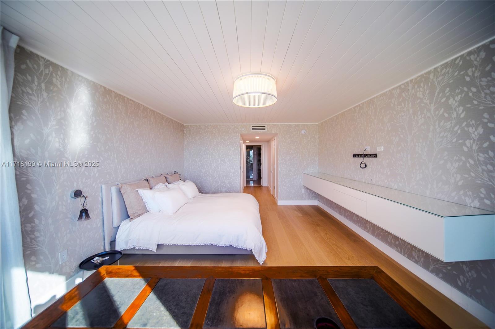 765 Crandon Boulevard, Unit 510 Key Biscayne, FL 33149 - Photo 19 of 28 a bedroom with a bed and a lamp with the wooden floor