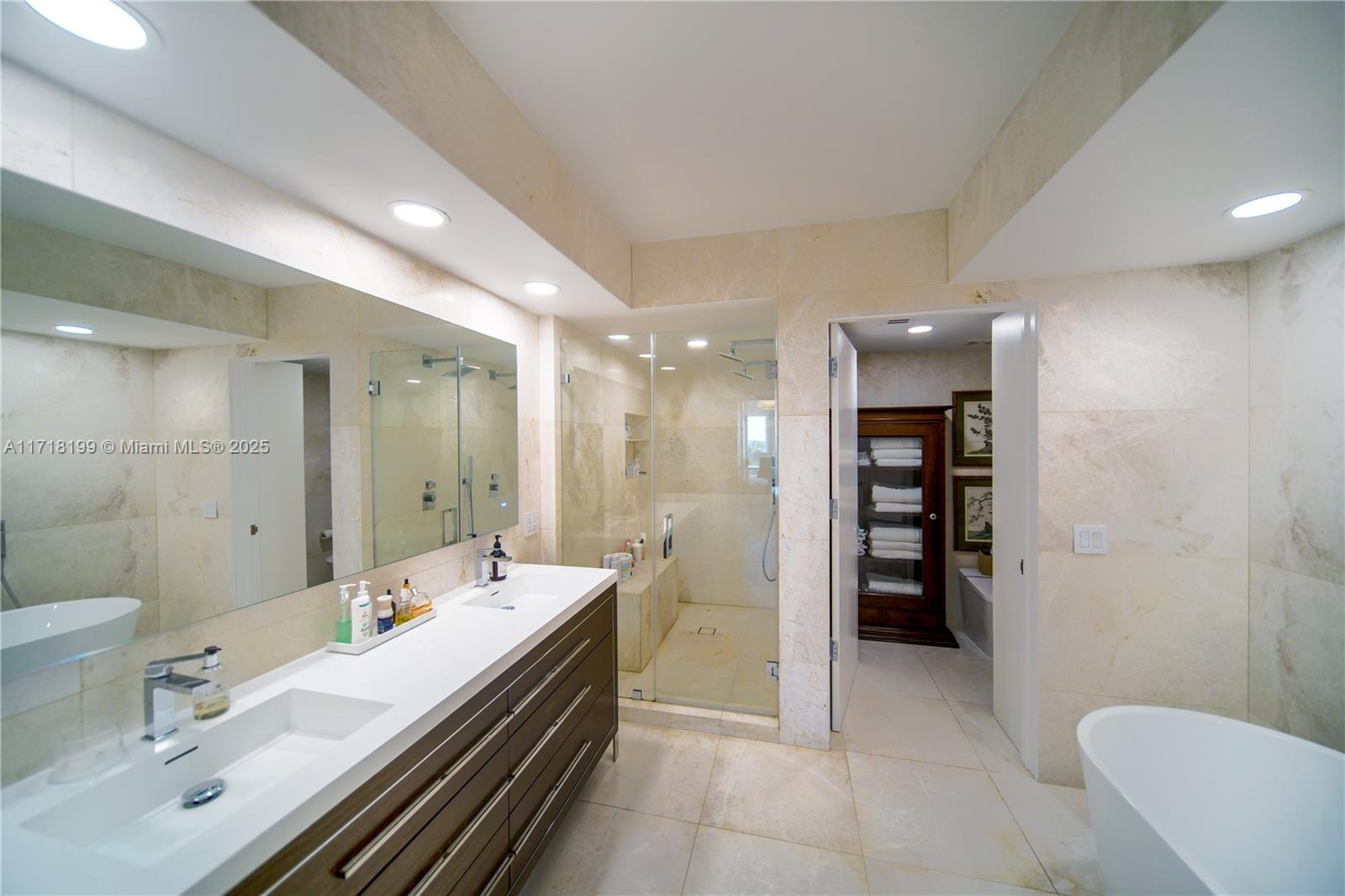 765 Crandon Boulevard, Unit 510 Key Biscayne, FL 33149 - Photo 22 of 28 a spacious bathroom with a double vanity sink a mirror and a bathtub