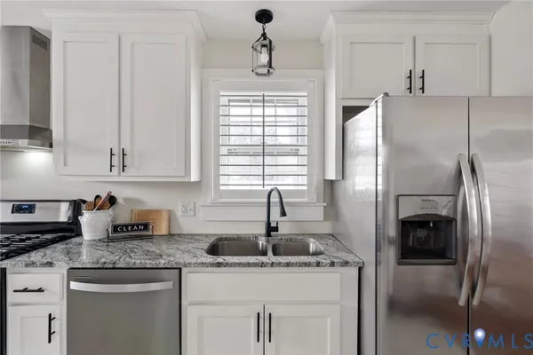 a kitchen with stainless steel appliances granite countertop a sink a refrigerator and a granite counter tops