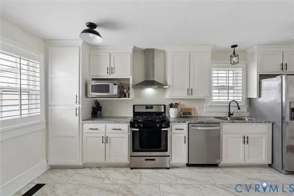 a kitchen with stainless steel appliances granite countertop a stove sink and cabinets