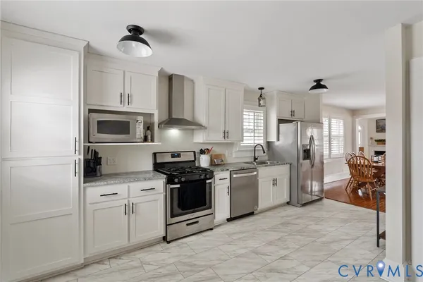 a kitchen with white cabinets and appliances