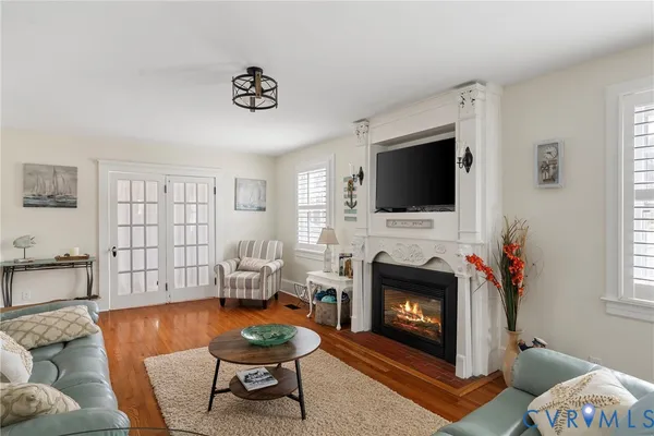 a living room with furniture a flat screen tv and a fireplace