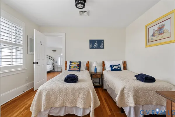 a bedroom with two bed and a large window