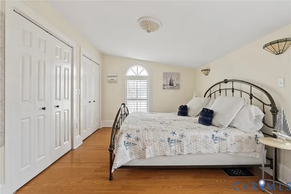 a bedroom with a bed window and a mirror