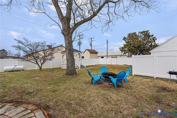 a view of a backyard with table and chairs and a large tree