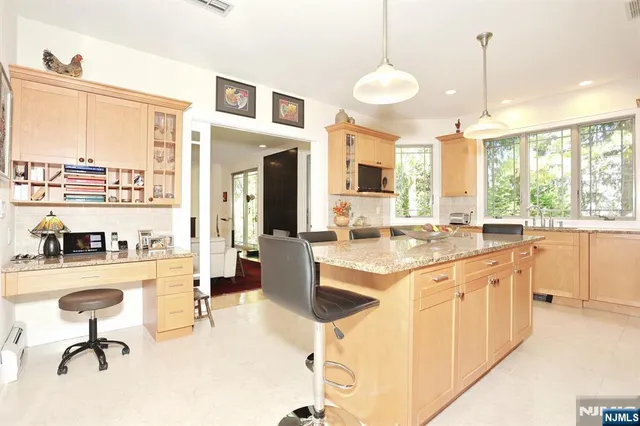 a open kitchen with stainless steel appliances granite countertop a stove top oven a sink dishwasher a dining table and chairs with wooden floor