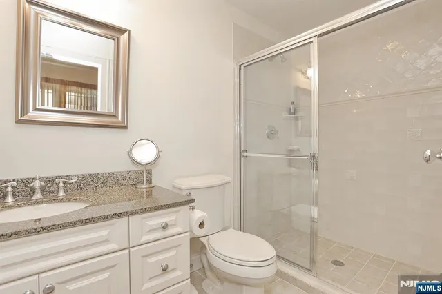 a bathroom with a granite countertop sink toilet and shower