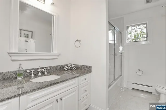 a bathroom with a granite countertop sink a mirror and a