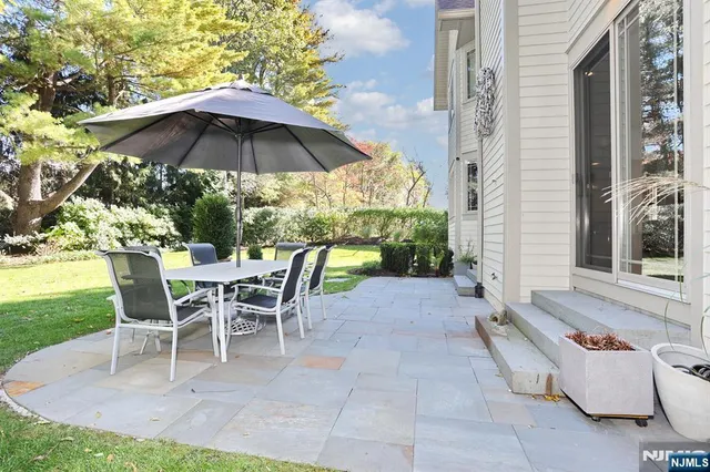 a view of a patio with a table and chairs under an umbrella