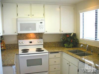 3058 Sunset Lane Oxnard, CA 93035 - Photo 6 of 10 a kitchen with granite countertop white cabinets and white appliances