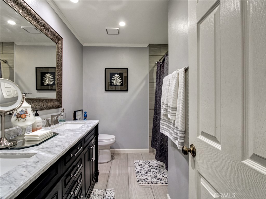 1669 Erin Avenue Upland, CA 91784 - Photo 13 of 27 a bathroom with a sink a toilet and a mirror