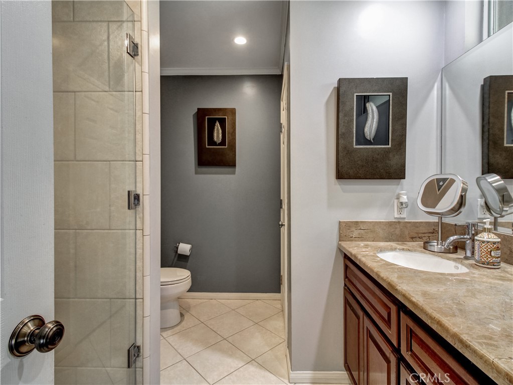 1669 Erin Avenue Upland, CA 91784 - Photo 18 of 27 a bathroom with a granite countertop sink a toilet and a mirror