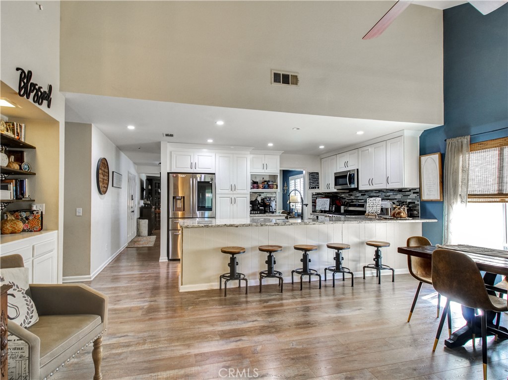 1669 Erin Avenue Upland, CA 91784 - Photo 2 of 27 a dining hall with stainless steel appliances kitchen island granite countertop a dining table chairs and a refrigerator