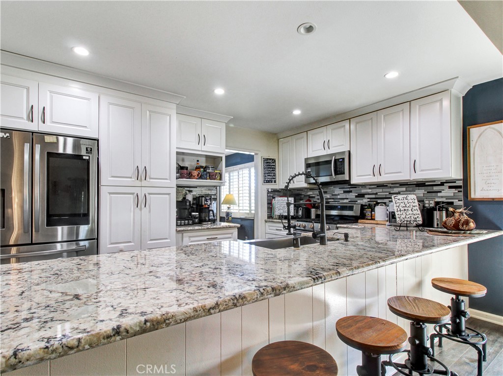 1669 Erin Avenue Upland, CA 91784 - Photo 7 of 27 a kitchen with stainless steel appliances granite countertop a sink refrigerator and cabinets