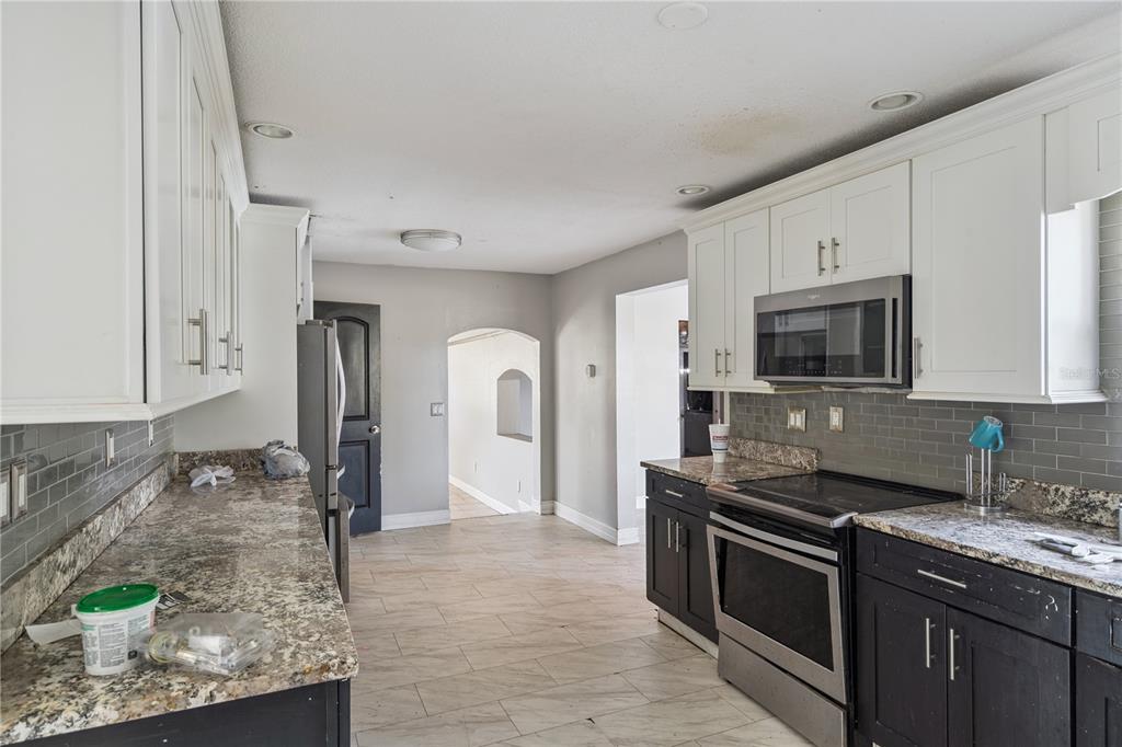 434 Diamond Acres Road Davenport, FL 33837 - Photo 7 of 20 a kitchen with stainless steel appliances granite countertop a stove a sink and a microwave