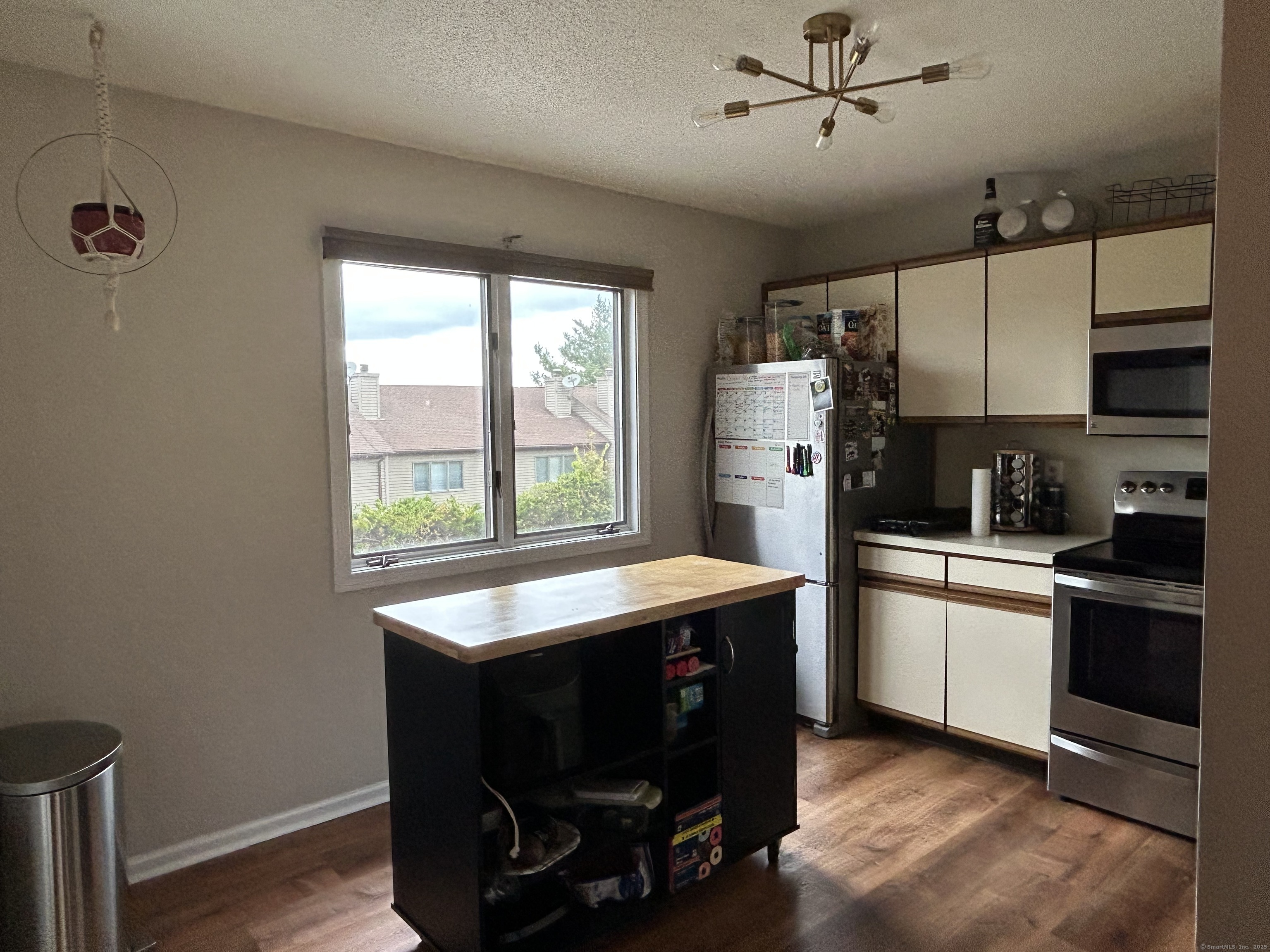 489 Wolcott Street, Unit 85 Bristol, CT 06010 - Photo 2 of 17 a kitchen with refrigerator cabinets and wooden floor