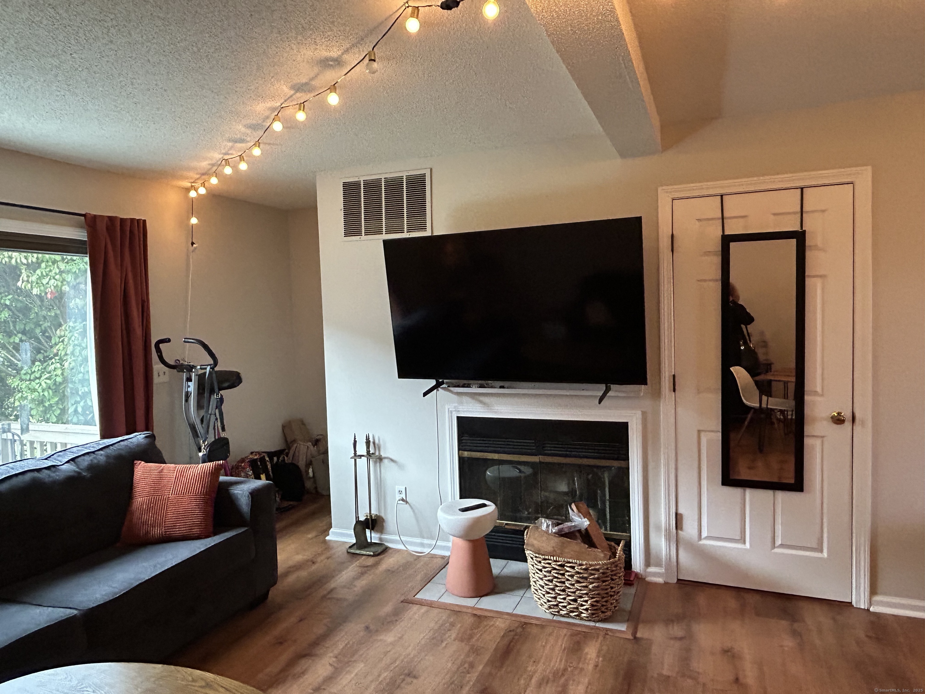 489 Wolcott Street, Unit 85 Bristol, CT 06010 - Photo 5 of 17 a living room with furniture a flat screen tv and a fireplace