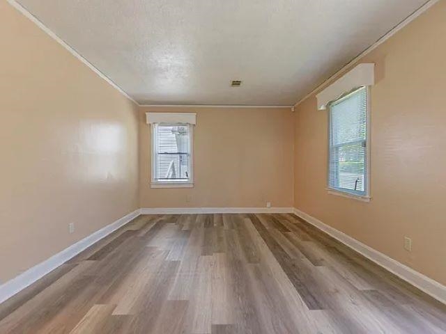 2061 Pendleton Street Memphis, TN 38114 - Photo 3 of 9 a view of an empty room with wooden floor and a window