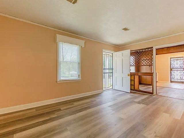 2061 Pendleton Street Memphis, TN 38114 - Photo 4 of 9 a view of an empty room with a window and wooden floor