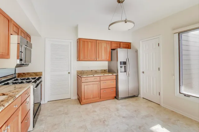 a kitchen with stainless steel appliances granite countertop a refrigerator and a stove top oven