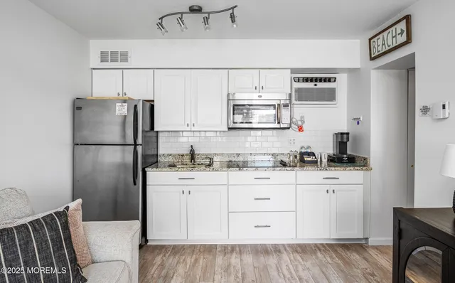 a kitchen with stainless steel appliances a refrigerator sink and cabinets