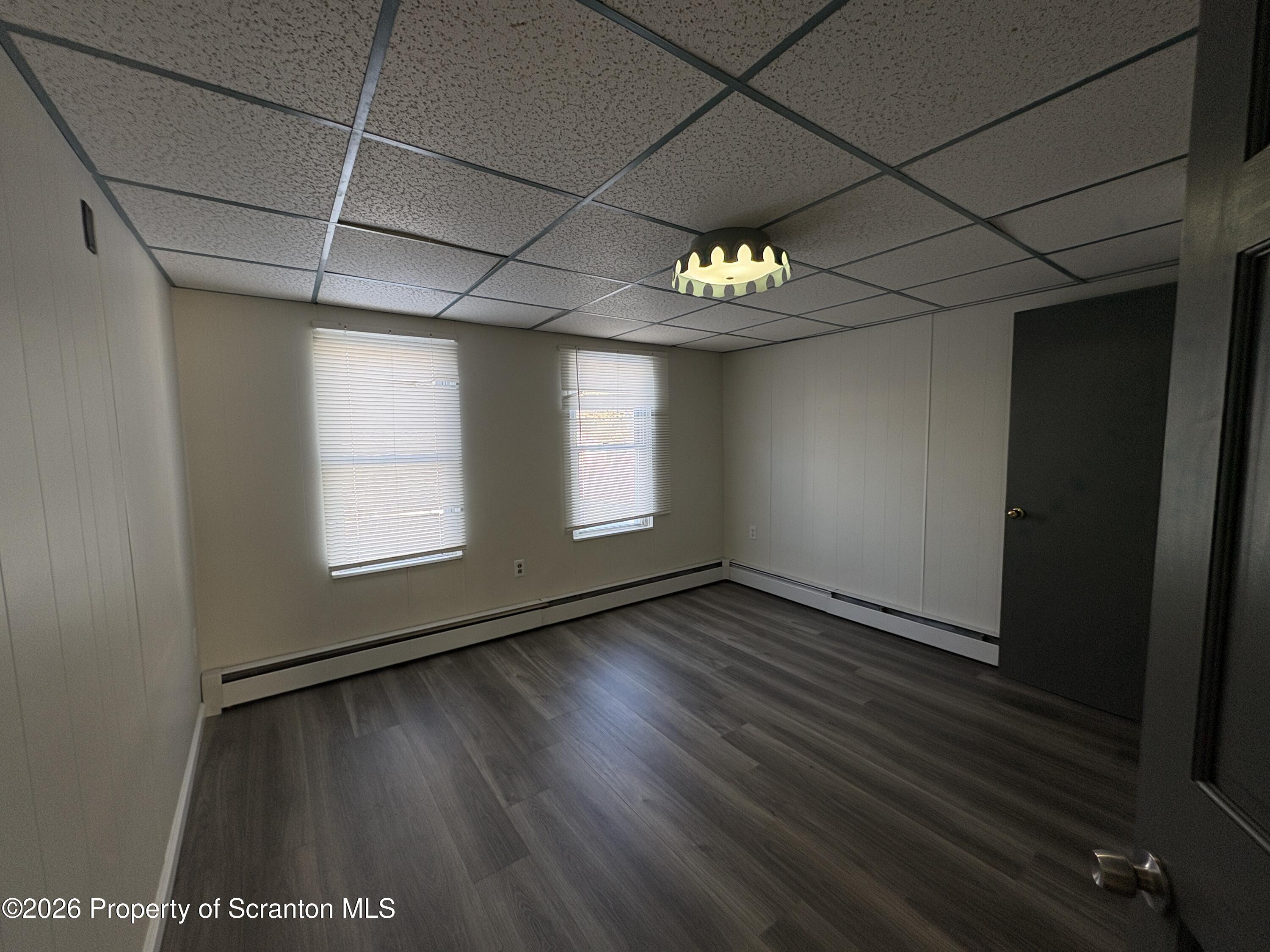 513 Oak Street Old Forge, PA 18518 - Photo 11 of 14 an empty room with wooden floor and windows