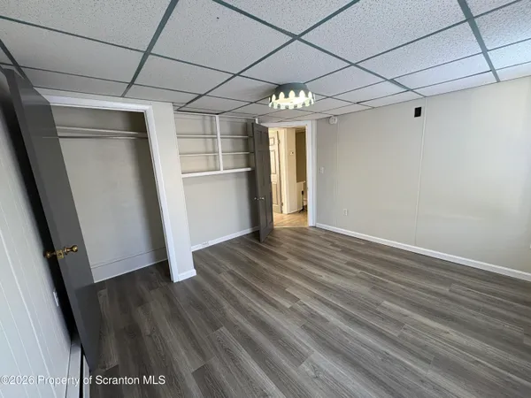 a view of empty room with wooden floor