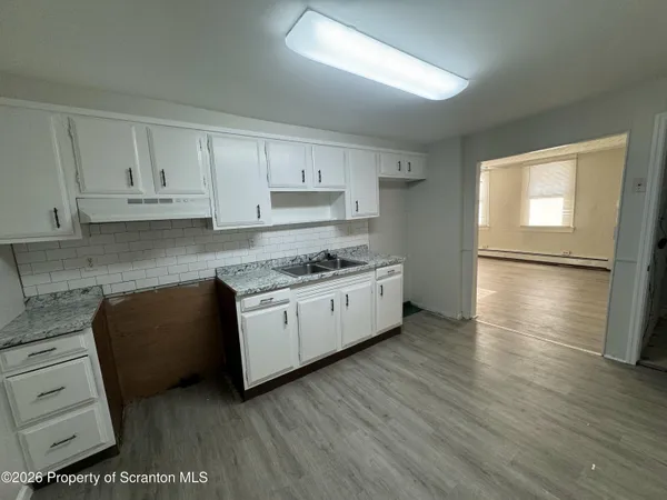 a kitchen with granite countertop a refrigerator and a stove top oven