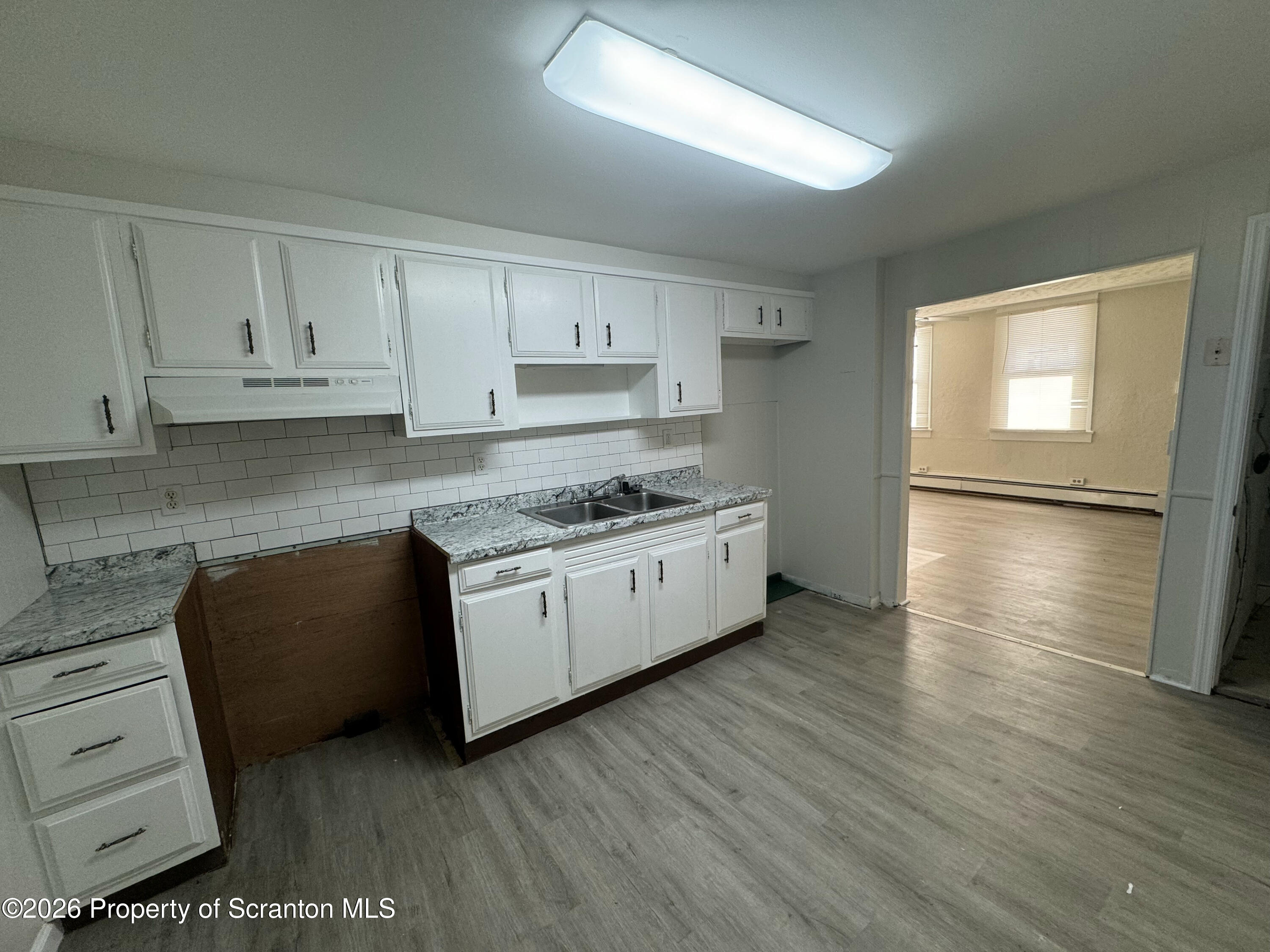 513 Oak Street Old Forge, PA 18518 - Photo 4 of 14 a kitchen with granite countertop a refrigerator and a stove top oven